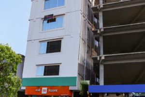 um edifício branco com um sinal na lateral em OYO Hotel Sonar Gaon em Agartala
