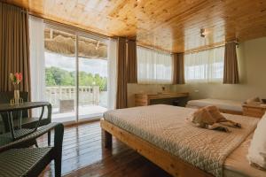 sypialnia z 2 łóżkami i dużym oknem w obiekcie Kaway Resort & Spa w mieście Tabuelan