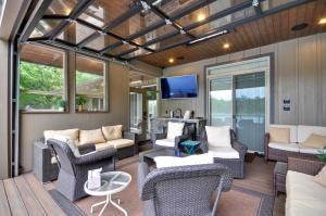 una veranda riparata con mobili e TV di Luxurious Waterfront Retreat with Private Pond! a Ridgefield