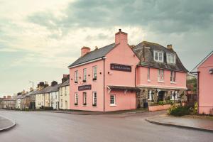 a row of pink houses on a street at Rose and Crown Yealmpton in Yealmpton