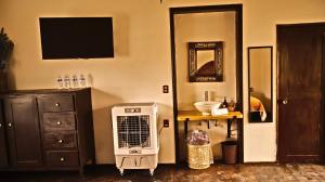 een kamer met verwarming, een kast en een televisie bij Casa Gardenia Hotel in Tecozautla
