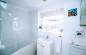 a white bathroom with a sink and a shower at 2 bed bungalow in Peacehaven