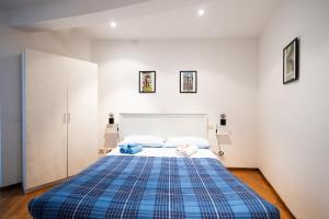 um quarto com uma cama com um cobertor xadrez azul em Casa Al Duomo em Parma