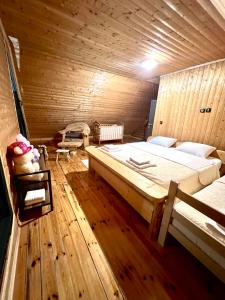 a bedroom with a large bed in a wooden room at Vila Tea Durmitor in Žabljak
