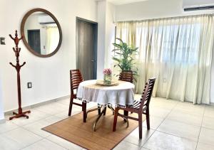 a dining room with a table and chairs and a mirror at Departamento climatizado excelente ubicación in Veracruz