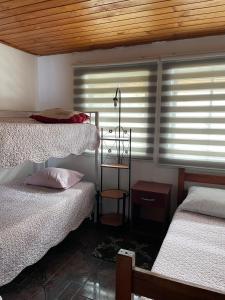 1 dormitorio con 2 camas y una ventana con persianas en Hospedaje La Blanquita, en Santa Juana
