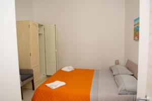 um quarto com uma cama com um cobertor laranja em RV CASA VACANZE em Vignacastrisi