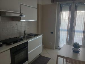 a kitchen with a sink and a stove and a table at FAMILY HOUSE in Modugno