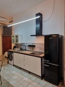 cocina con nevera negra y lavavajillas en Apartamento Pelayo, en Valencia