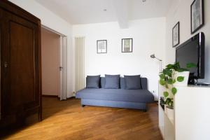 een woonkamer met een blauwe bank en een tv bij Casa Al Duomo in Parma