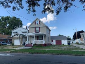 a white house with a red door on a street at Modern Getaway, Single Bedroom Full Apartment in Niagara Falls