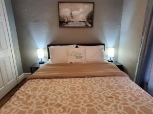 a bedroom with a bed with two lamps on both sides at Modern Getaway, Single Bedroom Full Apartment in Niagara Falls