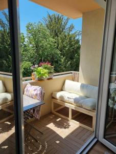 uma varanda com 2 cadeiras, uma mesa e uma janela em Superbe T3 cosy, parking gratuit + balcon em Riom