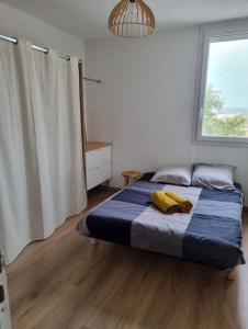 a bedroom with a bed with two yellow towels on it at Superbe T3 cosy, parking gratuit + balcon in Riom