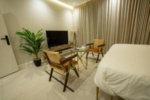 a bedroom with a bed and a table and a tv at شقق درر المفروشة تصميم إيطالي دخـول ذاتي in Riyadh