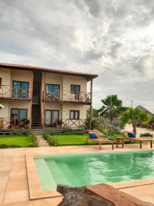 a villa with a swimming pool in front of a house at Pousada Makai - Cajueiro da Praia in Barra Grande