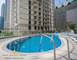 a large swimming pool with chairs and a building at Dunya tower Royal suite Burj Khalifa street, Kings in Dubai