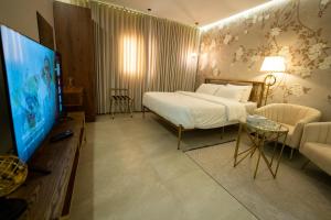 a hotel room with a bed and a television at شقق درر المفروشة تصميم إيطالي دخـول ذاتي in Riyadh