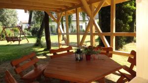 a wooden table in a pavilion with chairs and a swing at Heweliusz in Ustka
