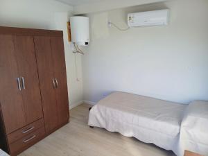 ein Schlafzimmer mit einem Bett, einer Kommode und einem Bett in der Unterkunft La Demorada, cómoda casa en entorno natural in Mercedes