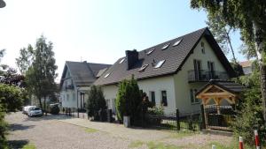 une grande maison blanche avec un toit noir dans l'établissement Heweliusz, à Ustka