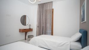 a hotel room with two beds and a mirror at Mystique Boutique Residence in Kalabaka