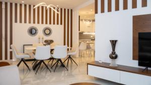 a dining room with a table and chairs and a television at Mystique Boutique Residence in Kalabaka