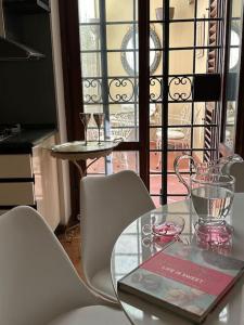 un tavolo in vetro con sedie e un libro sopra di ☆Lovely view of Florence in Stilish Designed Apt☆ a Fiesole