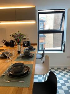 uma sala de jantar com uma mesa com pratos e copos de vinho em Contemporary City Centre 3 bedroom apartment em Sheffield