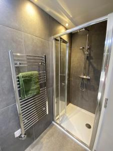 a shower with a glass door in a bathroom at Contemporary City Centre 3 bedroom apartment in Sheffield