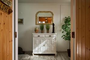 a white dresser with a mirror on top of it at Casas Maravilha - Casa Grande by Madeira Sun Travel in Calheta