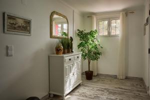 a room with a mirror and a cabinet with plants at Casas Maravilha - Casa Grande by Madeira Sun Travel in Calheta