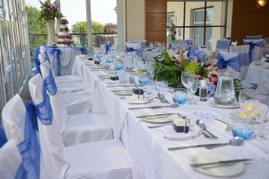 a table set up for a wedding with white table settings at The Riviera Hotel & Apartments - Alum Chine in Bournemouth
