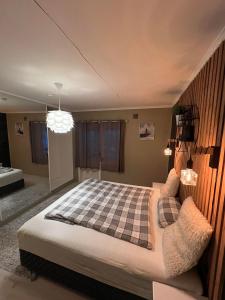 a bedroom with a bed with a checkered blanket at Flott sentral 3 roms leilighet in Bergen
