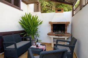 a patio with a fireplace and chairs and a table at Casa Fantástica in Playa Honda