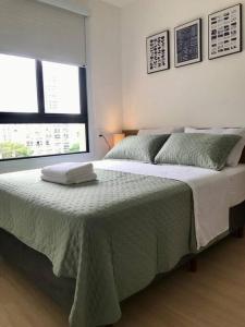 a white bedroom with a large bed with two windows at Apê 511 NEX ONE in Sao Paulo