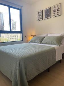 a bedroom with a large bed and a window at Apê 511 NEX ONE in Sao Paulo