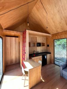 eine Küche und ein Wohnzimmer eines winzigen Hauses in der Unterkunft Refugios Pura vida in La Paloma