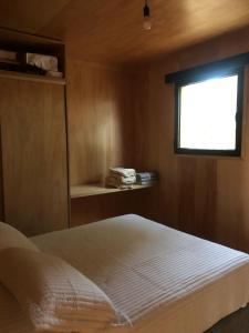 ein Schlafzimmer mit einem weißen Bett und einem Fenster in der Unterkunft Refugios Pura vida in La Paloma