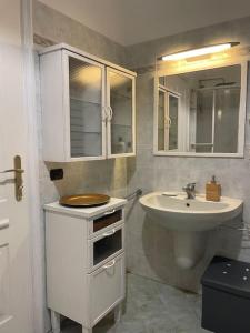 a white bathroom with a sink and a toilet at Appartamento centro storico in Via Palestro in Ivrea