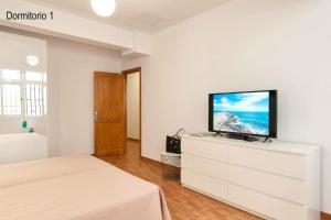 um quarto branco com uma televisão de ecrã plano numa cómoda em 3 bedrooms appartement with wifi at Las Palmas de Gran Canaria em Las Palmas de Gran Canaria