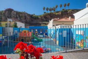 a swimming pool with a playground in a building at 2 bedrooms appartement with wifi at Camara De Lobos 4 km away from the beach in Funchal