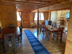 un comedor con mesas y sillas en una cabaña en Hospedaje Alto Palena de Puerto Cisnes, en Puerto Cisnes