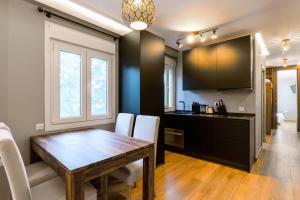 una cucina e una sala da pranzo con tavolo e sedie in legno di 2 bedrooms apartement with wifi at Sevilla a Siviglia