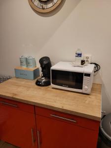 a microwave sitting on top of a counter at Petite maisonnette in Pont-Sainte-Maxence