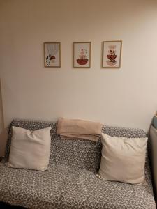 - une chambre dotée d'un lit avec 3 photos sur le mur dans l'établissement Petite maisonnette, à Pont-Sainte-Maxence
