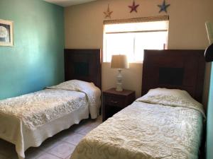 a bedroom with two beds and a window with stars on the wall at Almejas B in San Carlos