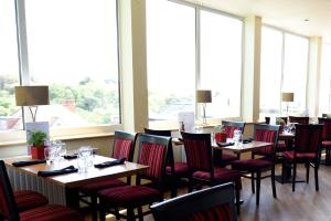 a restaurant with tables and chairs and large windows at The Riviera Hotel & Apartments - Alum Chine in Bournemouth