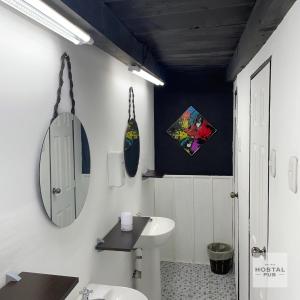 La salle de bains blanche est pourvue d'un lavabo et d'un miroir. dans l'établissement Hostal de fiesta - Hostal Pub, à Antigua Guatemala