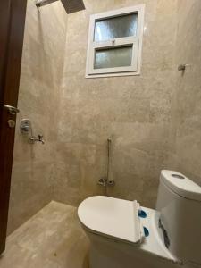 uma casa de banho com um WC e uma janela em لاڤانا em Unayzah
